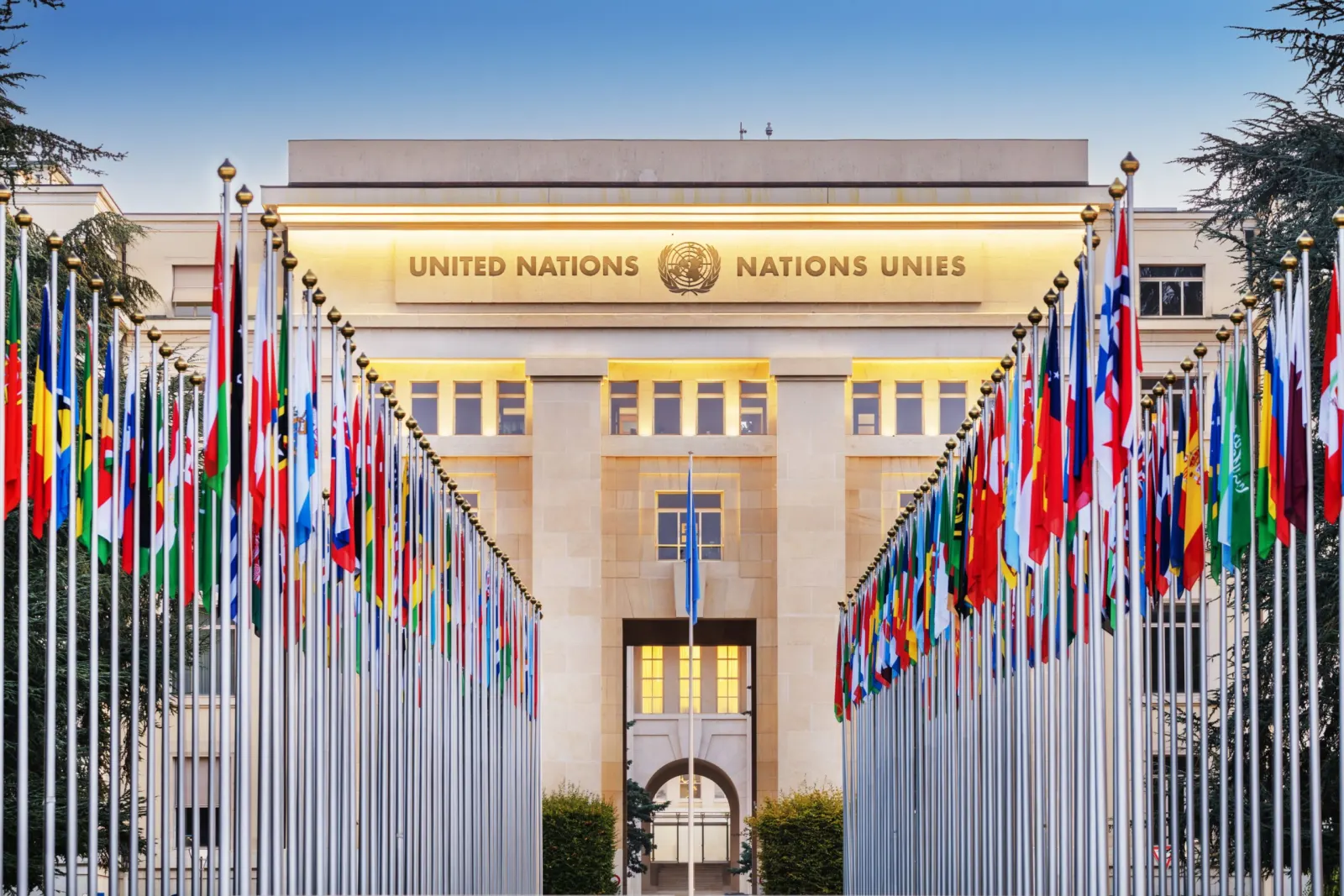 Façade du Palais des Nations à Genève, avec les drapeaux des pays membres de l’ONU alignés